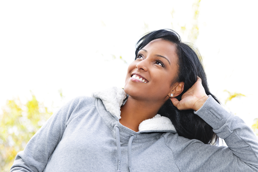 Smiling young woman outdoors looking up